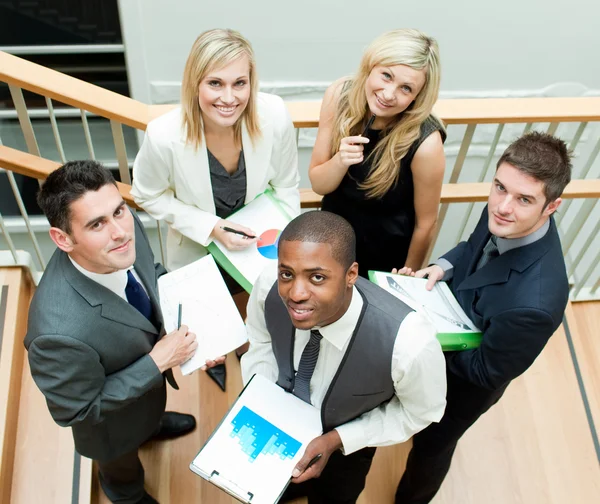 Business team working on stairs and smiling at the camera — Stock Photo, Image