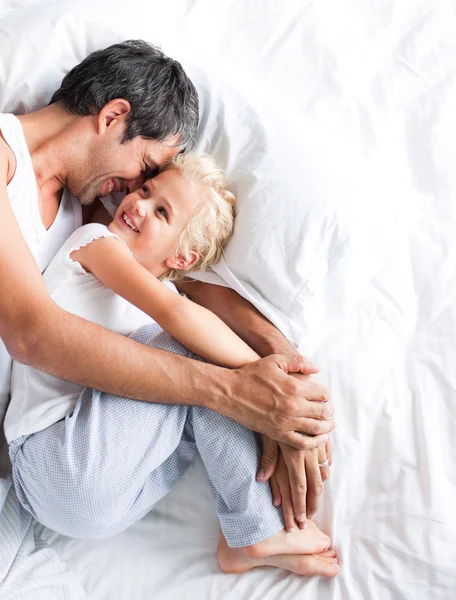 Father huggling her daughter on bed — Stock Photo, Image