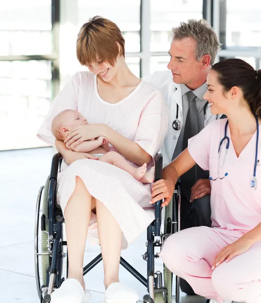 Paciente con su bebé recién nacido y médicos — Foto de Stock