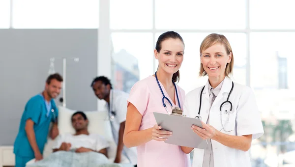 Attractive doctors attending to a patient — Stock Photo, Image