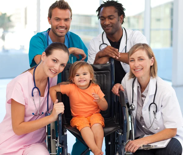 Grupo de médicos con un bebé en silla de ruedas — Foto de Stock