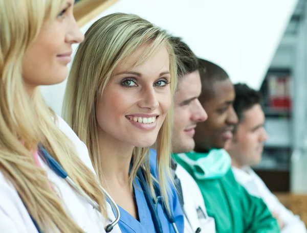 Portret van vrouwelijke arts glimlachen op de camera met haar team in een lijn op de trap — Stockfoto