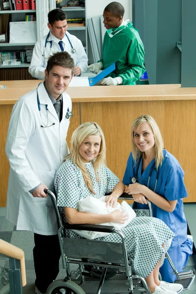 Lékaři s pacientem a její novorozené dítě — Stock fotografie