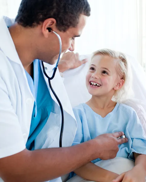 Male doctor checking the pulse on a smiling little patient — Stock Photo, Image
