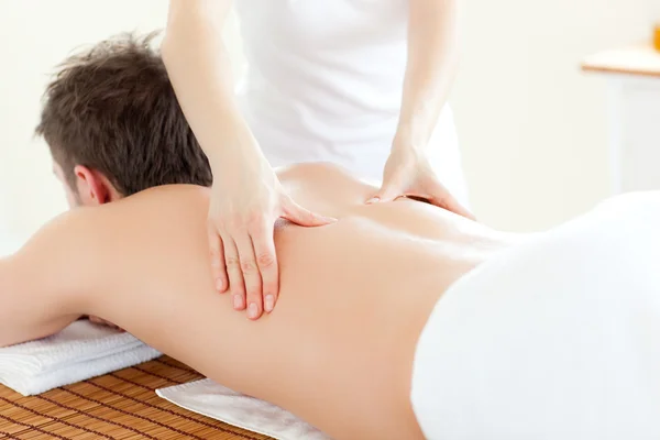 Caucsasian giovane uomo ricevendo un massaggio alla schiena — Foto Stock