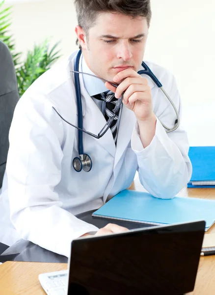 Zaniepokojony mężczyzna lekarz za pomocą laptopa — Zdjęcie stockowe