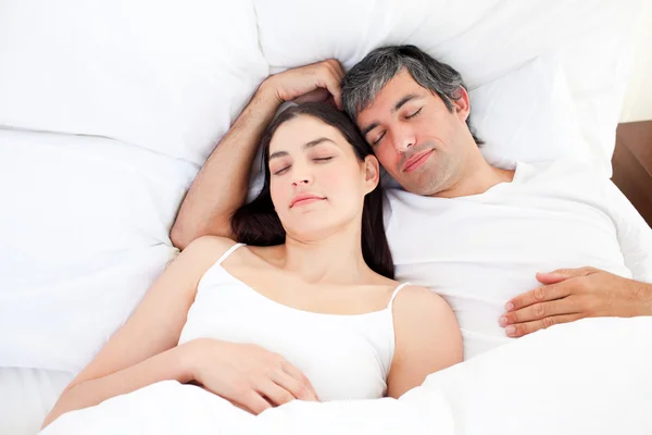 Casal afetuoso abraço deitado em sua cama — Fotografia de Stock