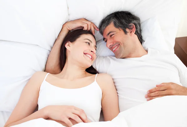 Влюбленная пара, обнимающая лежащую в постели — стоковое фото