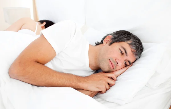 Uomo sconvolto sdraiato nel suo letto — Foto Stock