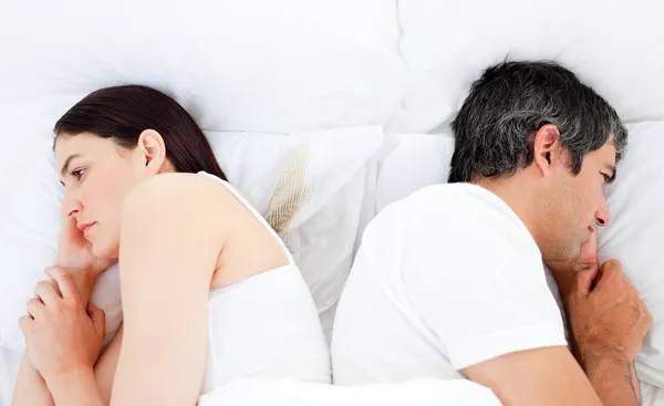 Verärgertes Paar schläft getrennt im Bett — Stockfoto