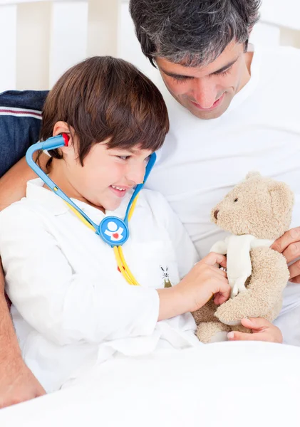 Père attentionné et son fils malade jouant avec un stéthoscope — Photo
