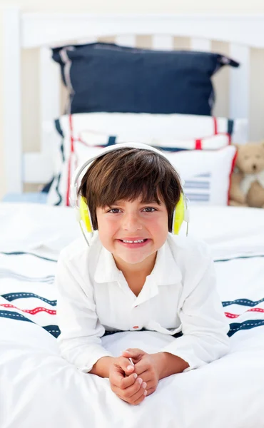 Leende liten pojke lyssnar musik med hörlurar på — Stock fotografie