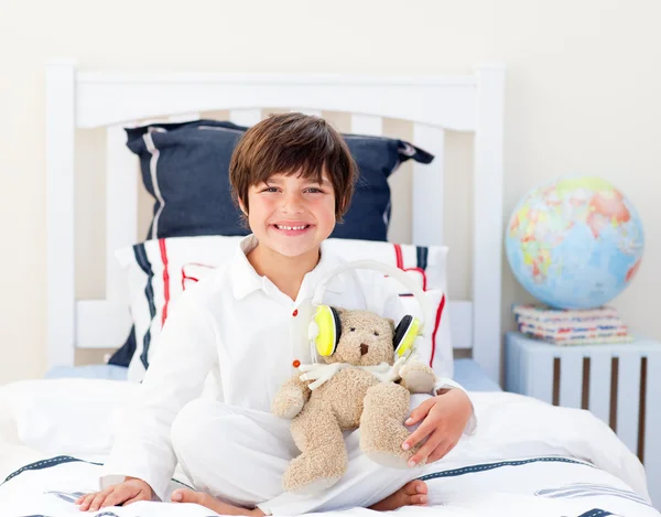 Happy little boy playing with a teddy bear — Stock Photo, Image