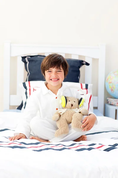 Lächelnder kleiner Junge beim Spielen mit einem Teddybär — Stockfoto