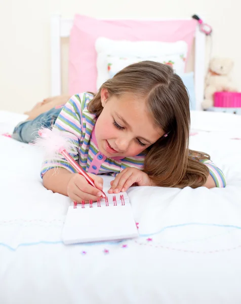 Συμπυκνωμένο μικρό κορίτσι, γράφει σε ένα σημειωματάριο — Φωτογραφία Αρχείου
