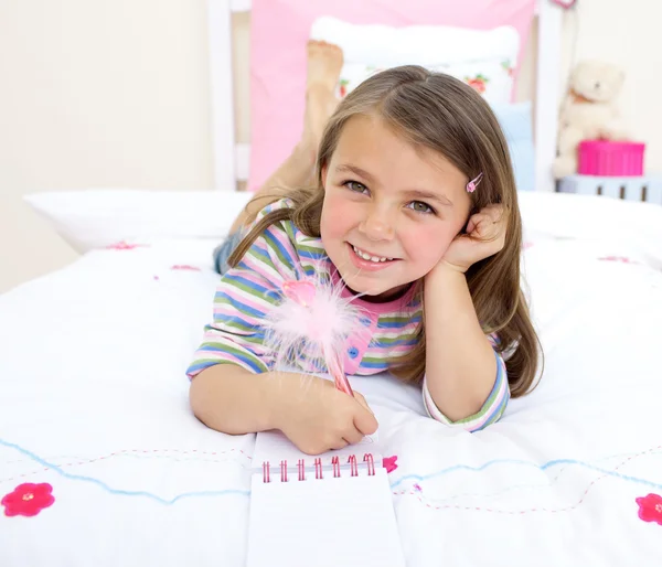 Leende liten flicka spela på hennes säng — Stockfoto
