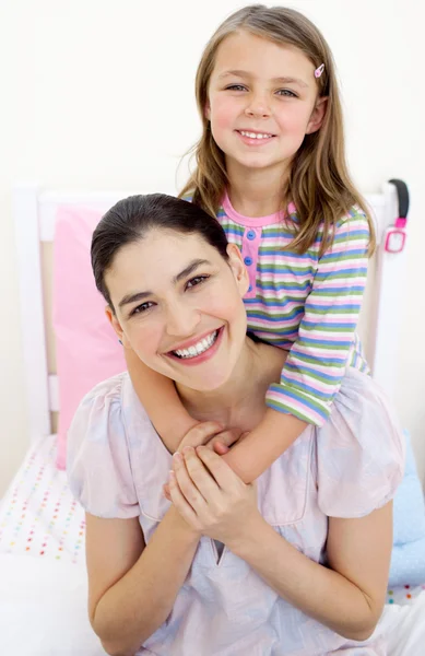 Uśmiechnięta dziewczynka przytulanie jej matka — Zdjęcie stockowe