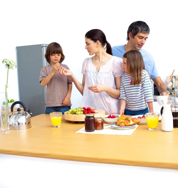 Jovem família alegre tomando um café da manhã — Fotografia de Stock