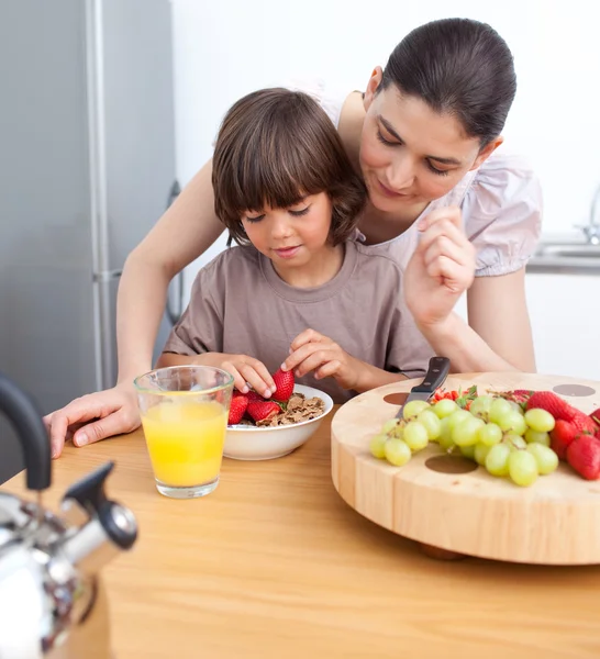 Sorridente madre e suo figlio che fanno colazione — Foto Stock