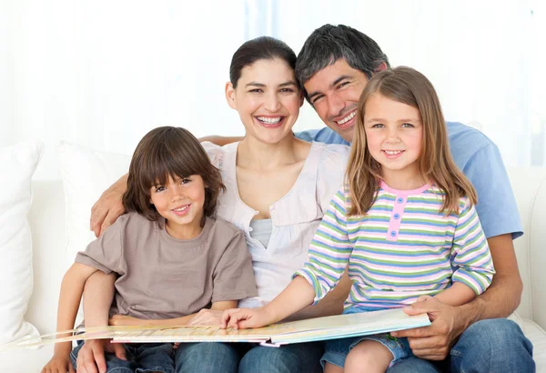 Vrolijke familie samen lezen op de Bank — Stockfoto