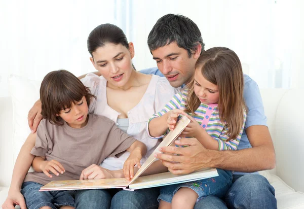 Attentive parents reading with their children — Stock Photo, Image