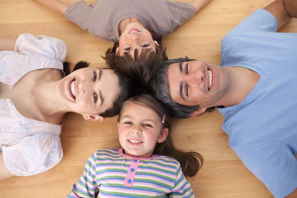 Levendige familie liggend op de vloer — Stockfoto