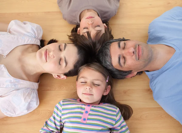 Fröhliche Familie schlafend auf dem Boden liegend — Stockfoto