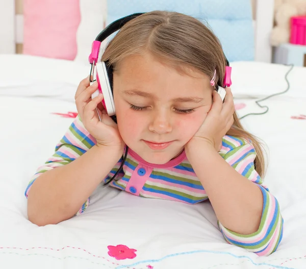 一个小女孩听听音乐用耳机的特写 — 图库照片