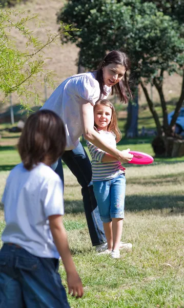 Gelukkig moeder frisbee spelen met haar kinderen — Stockfoto