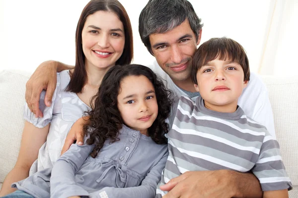 Portrait of a loving family sitting on a sofa — Stock Photo, Image