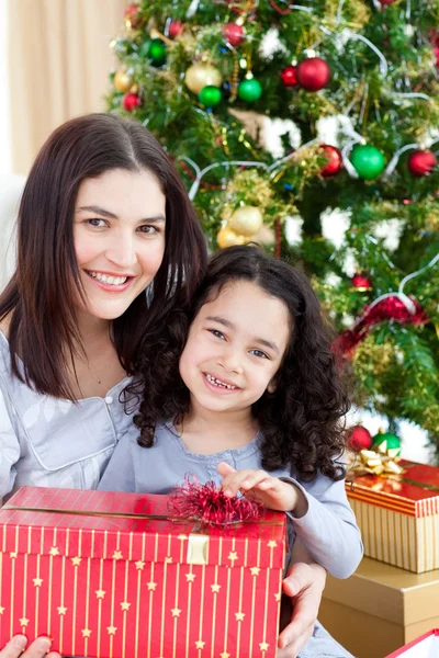 Madre e hija en casa sosteniendo un regalo de Navidad —  Fotos de Stock