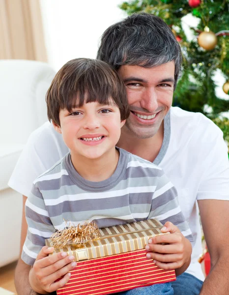Far och son håller en julklapp — Stockfoto