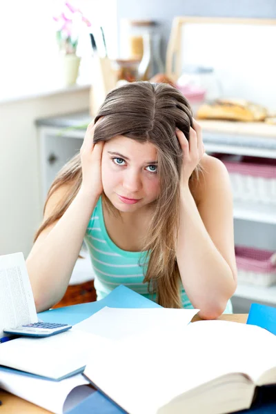 Estudiante deprimida haciendo su tarea en un escritorio — Foto de Stock