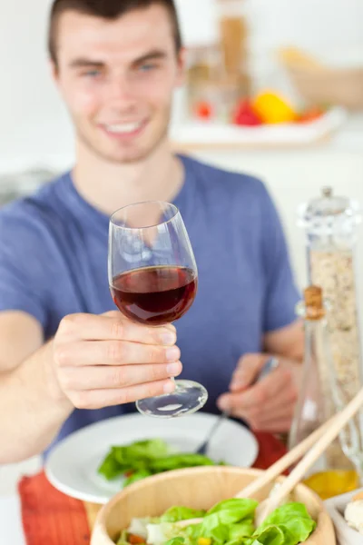 Caucasian man eating a healthy salad with some wine — Stock Photo, Image