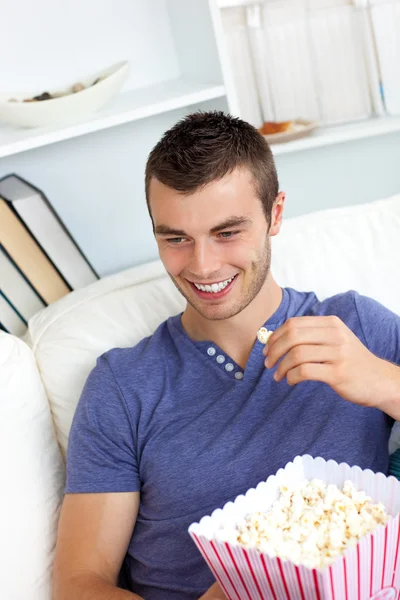 Attractive man is relaxing in the living-room with a remote — Stock Photo, Image