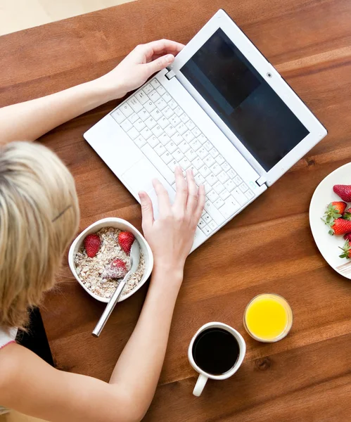 금발 여자 집에서 아침 식사 하는 동안 노트북을 사용 하 여 — 스톡 사진