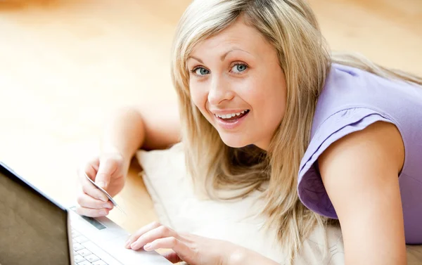 Ljusa kvinnan använder en bärbar dator i vardagsrummet — Stockfoto
