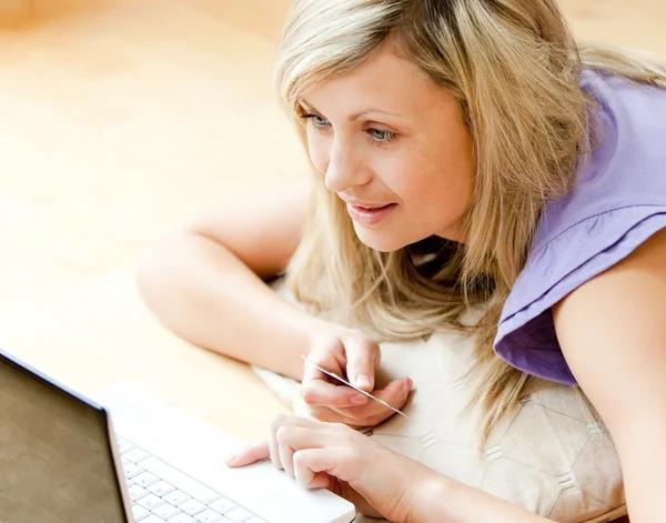 Яскрава жінка використовує ноутбук у вітальні — стокове фото