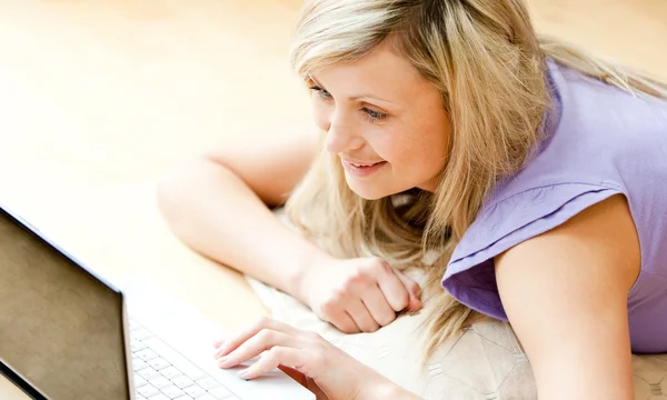 Ljusa kvinnan använder en bärbar dator i vardagsrummet — Stockfoto