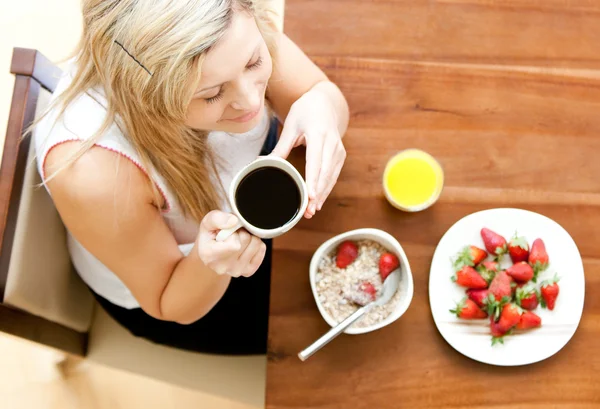 Vacker kvinna med en hälsosam frukost i ett vardagsrum — Stockfoto