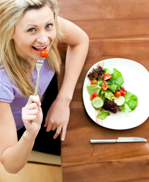 Ritratto di una bella donna che mangia un'insalata in salotto — Foto Stock