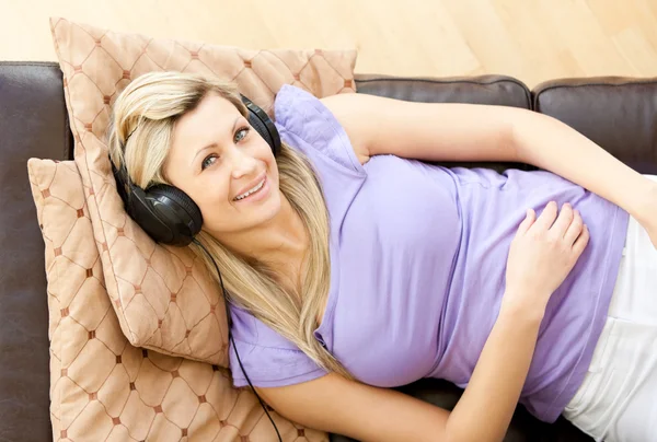 Bella donna sta ascoltando la musica in salotto a casa — Foto Stock