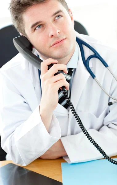 彼のオフィスに電話で話しているハンサムな男性医師 — ストック写真