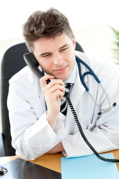 Όμορφος αρσενικό γιατρό του μιλώντας στο τηλέφωνο στο γραφείο του — Φωτογραφία Αρχείου