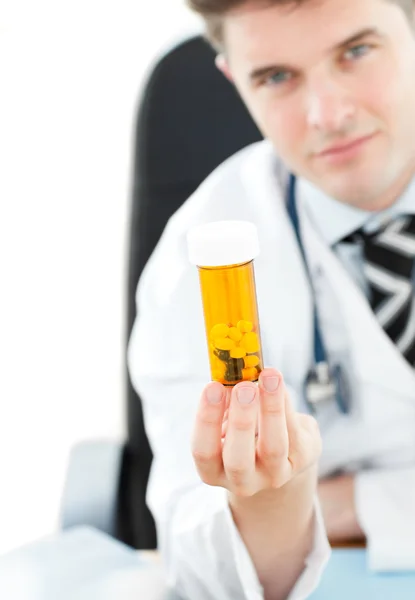 Doktor drží pilulky ve své kanceláři — Stock fotografie