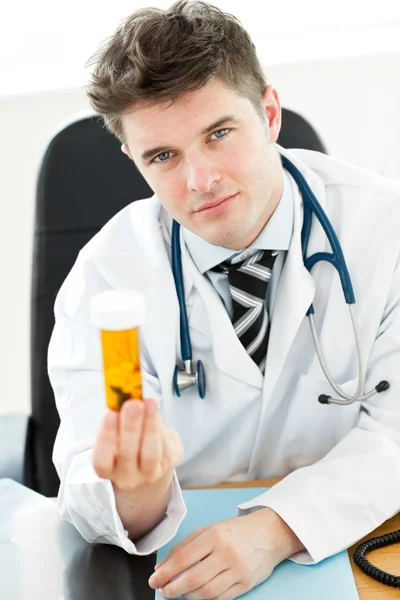 Doctor holding pills in his office — Stock Photo, Image