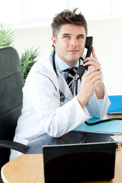 Confident male doctor talking on the phone in his office — Stock Photo, Image
