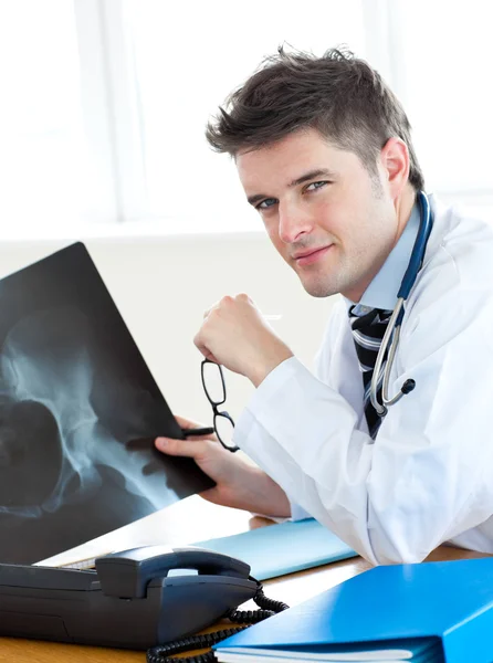Gutaussehender Chirurg analysiert ein Röntgenbild — Stockfoto