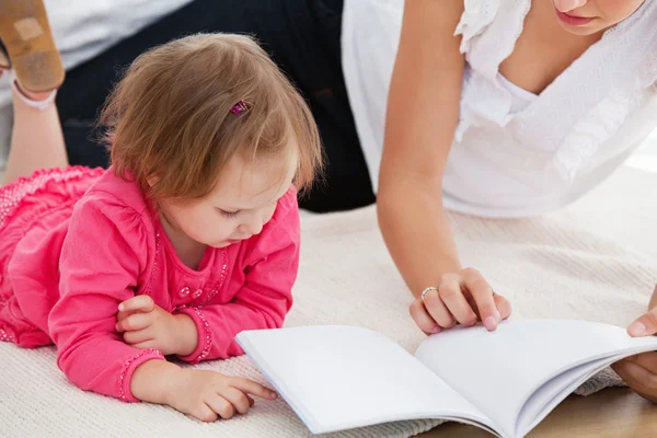 Snäll mamma läser en bok med barn — Stockfoto