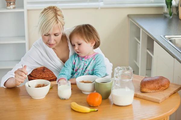 Mãe e linda filha tomando café da manhã — Fotografia de Stock